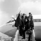 The Beatles, wearing cape-type coats, on the steps of the plane on arrival at London Airport from their Australian tour. At a Press Conference at the airport Lennon denied a rumour that he was leaving the group.