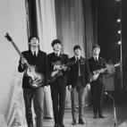 1963: Pop group The Beatles take a bow on stage after performing in the Royal Command Performance at the Prince of Wales Theatre. (Photo by Fox Photos/Getty Images)