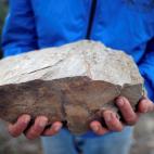 Carlos Sanz, un vecino de la zona, muestra una piedra de pizarra, el maldito material que tanto ha complicado los trabajos.