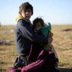 Un ni&ntilde;o cuida de su hermano tras escapar de Baghouz.