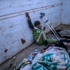 Un hombre y una mujer heridos esperan a ser atendidos, sobre un cami&oacute;n destartalado.