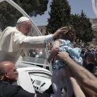 Francisco besa a un niño desde el papamóvil mientras abandona la Plaza Manger de Belén.