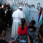 El papa Francisco ora en la barrera de separación entre territorios.