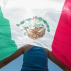 Kimberly Esparza protesta con una bandera mexicana por la llegada de Trump a Laredo, Texas.