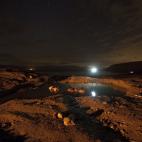 Fotografía de larga exposición que muestra a un grupo de israelíes esperando a ver una lluvia de meteoros de las Gemínidas mientras toman un baño cerca a las costas del mar Muerto en Israel.