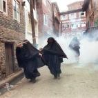 Mujeres musulmanas con purdah huyen de los gases lacrimógenos lanzados durante una manifestación en Srinagar el 3 de septiembre de 1996.