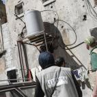 Los ingenieros hidráulicos están instalando y reparando las tuberías de agua, cisternas y grifos para conseguir que fluya de nuevo después de que fuera destruido en una de las luchas del barrio.