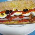 Con lacón, escalibada, huevo, alcaparras, tomate... ¡Cuidado si lo llenas mucho o te costará darle un bocado! Consulta la receta completa en Cookpad