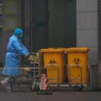 Un trabajador del Centro Médico de Wuhan traslada restos