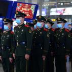 Agentes de policía vigilan una de las estaciones de tren en China, todos ellos con máscaras para evitar contagios