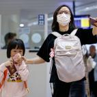 Una mujer y su hija, con mascarillas en el aeropuerto de Manila (Filipinas)