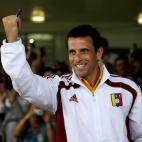 Opposition presidential candidate Henrique Capriles shows his inked finger which was marked after casting his ballot in the presidential election in Caracas, Venezuela, Sunday, April 14, 2013. Capriles is running for president against Nicolas Ma...