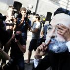 Un manifestante con una máscara de Mariano Rajoy espera a las puertas de la Audiencia Nacional.