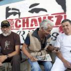 Residents sit as they wait on line to vote in the presidential election in Caracas, Venezuela, early Sunday, April 14, 2013. Interim President Nicolas Maduro, who served as late President Hugo Chavez's foreign minister and vice president, is run...