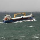 Un barco sale de la ría de Ferrol, a pesar del fuerte temporal que azota la costa.