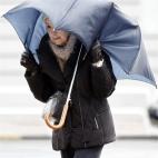 Una mujer sujeta con sus manos el paraguas en Pamplona (Navarra).