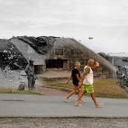 Los bañistas caminan cerca de un búnker alemán con vistas a la playa de Omaha, cerca de Saint-Laurent-sur-Mer