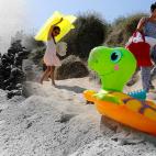Niños caminan sobre los restos de un muro de hormigón en la antigua playa de Utah, zona de aterrizaje del Día D.