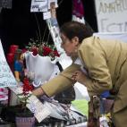 Una mujer coloca flores afuera del hospital Favaloro, donde fue operada con éxito de un hematoma en el cerebro la presidenta argentina Cristina Fernández. Buenos Aires, martes 98 de octubre de 2013. (AP Photo/Victor R. Caivano)