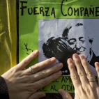 Una mujer pone un cartel que muestra una imagen de la presidenta Cristina Fernández de Argentina y su difunto esposo, el ex presidente Néstor Kirchner, a la derecha, que dice: "fuerza compañera, te juro que en los malos momentos los pibes sie...