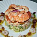 Los ingredientes son langostinos, gambas, aguacate, zanahoria rallada, lechugas varias, tomate, palitos de cangrejo, cebolla caramelizada y pan frito. Para preparar la vinagreta se necesita salsa golf, nata de cocinar, aceite de oliva, vinagre d...