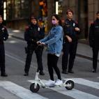 Una joven circula con su patinete en los aledaños de la plaza Sant Jaume, cuyos accesos se ven restringidos por el dispositivo de seguridad desplegado desde primera hora de la mañana ante el Palau de la Generalitat.