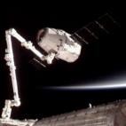 Esta imagen suministrada por NASA-TV muestra al vehículo comercial de carga Dragon de SpaceX, arriba, luego de ser asido por un brazo automático para conectarlo a la Estación Espacial Internacional el viernes 25 de mayo de 2012. SpaceX anunci...