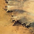 "Arid fingers of sand-blasted rock look like they're barely holding on against the hot Saharan wind."
