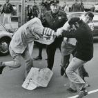 Un miembro del Ku Klux Klan y un manifestante por la igualdad pelean durante una marcha en Boston en 1978, frente a un polic&iacute;a que no hace nada.