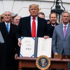 Firmando el nuevo acuerdo de comercio con Canad&aacute; y M&eacute;xico.