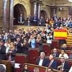 Diputados del Partido Popular levantan banderas de España y Cataluña al finalizar la votación.