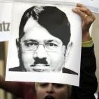 An Egyptian activist shouts slogans as she holds a poster depicting Egyptian Islamist President Mohammed Morsi doctored to resemble Adolf Hitler during a protest outside the Egyptian foreign ministry during a visit by U.S. Secretary of State Joh...