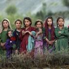 Niñas del remoto poblado de Ghumaipayan Mahnow, al norte de Afganistán, cerca de la frontera con Tajikistán, observan cómo trabajadores de Naciones Unidas descargan urnas electorales de un helicóptero para poder llevar a cabo las primeras v...