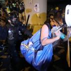 Un manifestante trata de protegerse de los antidisturbios.