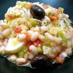Lleva bacalao, huevos duros, pimiento italiano, pimiento rojo, cebolleta, tomate pera, orégano, aceite y vinagre. Para tardar menos en la elaboración se puede recurrir a judías blancas de bote.