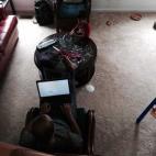 "El pequeño de 4 años cortando papel en trocitos pequeños mientras su padre trabaja en el ordenador".