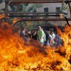 Un contenedor incendiado al término de la protesta en Valencia.
