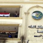 Opositores sostienen una bandera egipcia después del asalto.