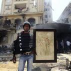 Un egipcio viste un chaleco de seguridad presuntamente utilizado por miembros de los Hermanos Musulmanes e incautado en el asalto a la sede.