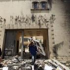 Un ciudadano saca una puerta tras la quema y el asalto de la sede de los Hermanos Musulmanes.