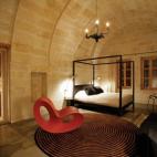 La lujosa decoración de esta habitación, como el candelabro negro de la imagen, del holandés Moooi, es una muestra de cómo lo moderno se mezcla perfectamente con la edad de piedra en este lugar.