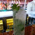 120 ml. de ron añejo (blanco o golden) jugo de lima 1 rama de hierbabuena 2 cucharas de azúcar blanco 2 onzas de agua de sifón o soda Vetemos el jugo de media lima y el azúcar en el vaso y machacamos con un mortero. Agregamos la hierbabue...