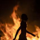 Manifestante en Jerusal&eacute;n, ante un coche ardiendo.