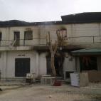 In this Monday, Oct. 8, 2012 photo taken with a mobile phone, a police officer walks past a burnt out shopping mall in Maiduguri, Nigeria. (AP Photo/Abdulkareem Haruna)