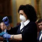 Una se&ntilde;ora de la limpieza desinfecta el atril, este mi&eacute;rcoles en el Congreso, tras la intervenci&oacute;n del presidente del Gobierno, Pedro S&aacute;nchez.