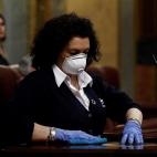 Una se&ntilde;ora de la limpieza desinfecta el atril, este mi&eacute;rcoles en el Congreso, tras la intervenci&oacute;n del presidente del Gobierno, Pedro S&aacute;nchez.