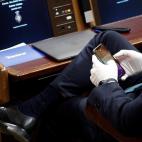 Un diputado consulta su móvil con guantes