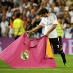 Una imagen clásica tras las victorias del Madrid. Raúl cogió su capote y 'toreó' sobre el césped