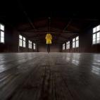 Una mujer visita el interior de uno de los pocos barracones que aún quedan intactos.