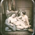 Dos mujeres desnudas sentadas en el suelo sobre unos cojines. Daguerrotipo estereoscópico coloreado a mano. 1850.